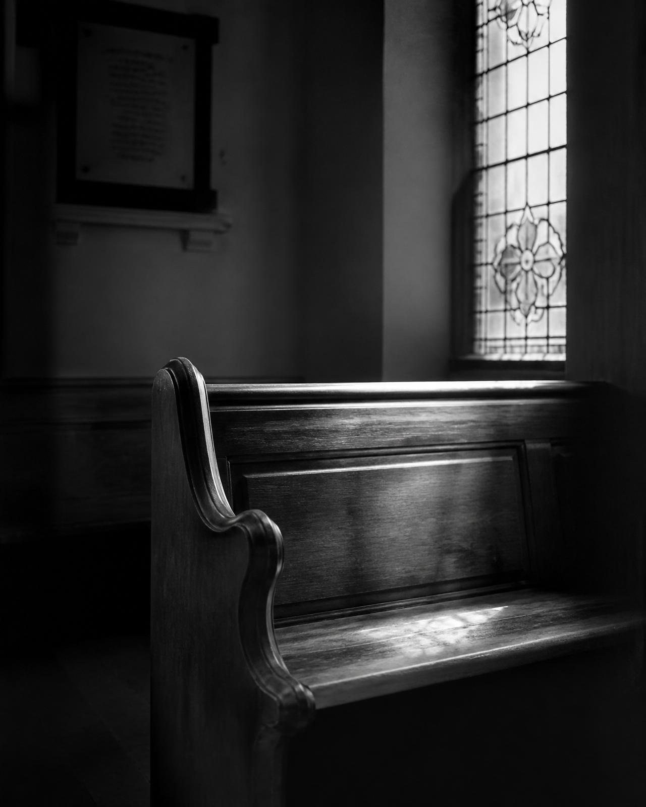Church pew under stained glass